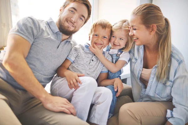 Flickan att göra hennes bror Le med föräldrar — Stockfoto