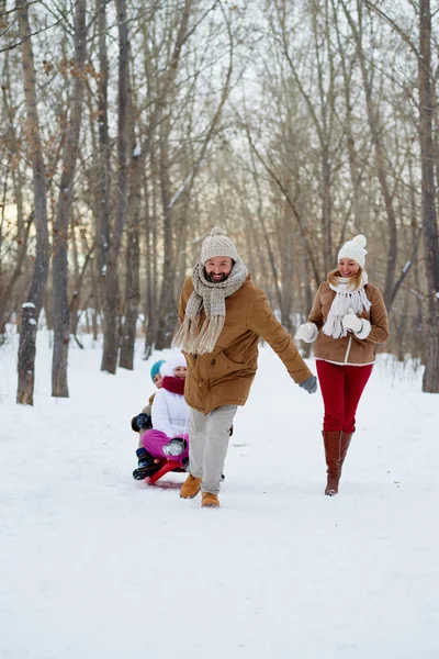 Man pulling sledge with kids — Stock Photo, Image