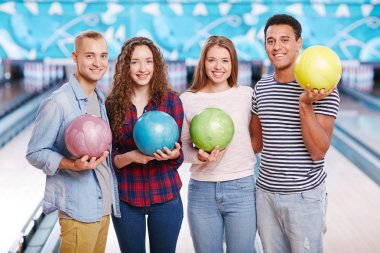 bowling topları tutan dört arkadaş