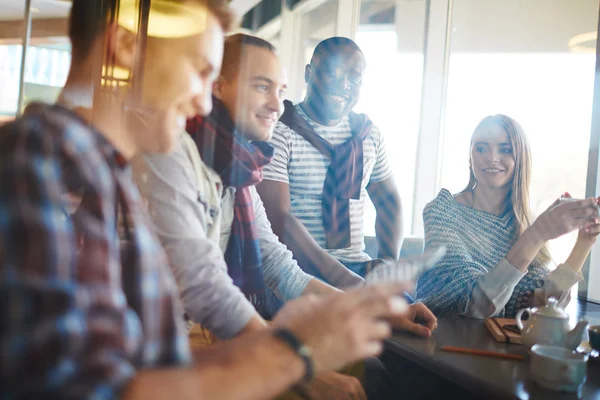 Young friends sitting in cafe — Stock Photo, Image