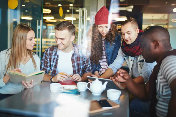 Friends doing homework in cafe — Stock Photo, Image