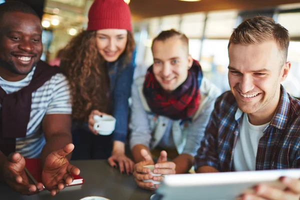 Tipo mirando touchpad con amigos — Foto de Stock