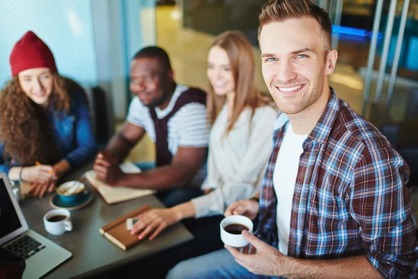 Подросток с друзьями, сидящими в кафе — стоковое фото
