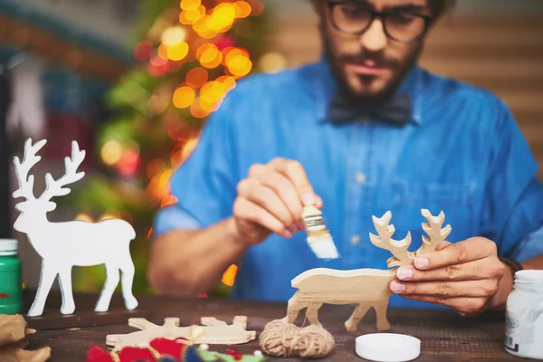 Man painting toy Christmas symbol — Stock Photo, Image