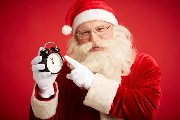 Santa Claus visar på väckarklocka — Stockfoto