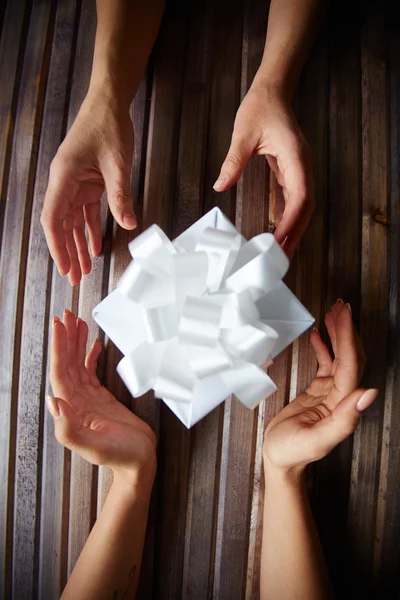 Female hands giving and taking gift-box — Stock Photo, Image