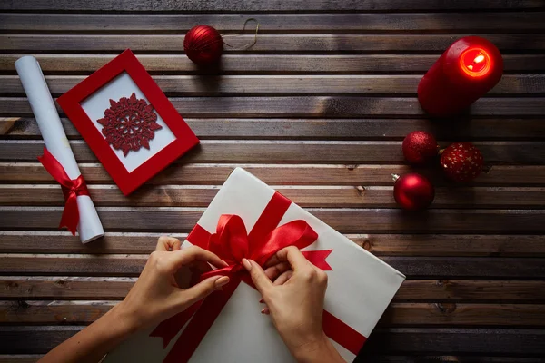 Weibliche Hände binden Knoten an Geschenkbox — Stockfoto