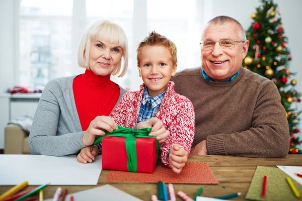 Großeltern und ihr Enkel mit Geschenkbox — Stockfoto