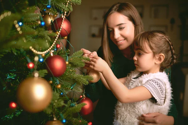 Meisje en moeder Christmas tree decoreren — Stockfoto