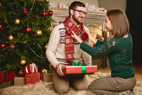 Glückliches Paar sitzt am Tannenbaum — Stockfoto