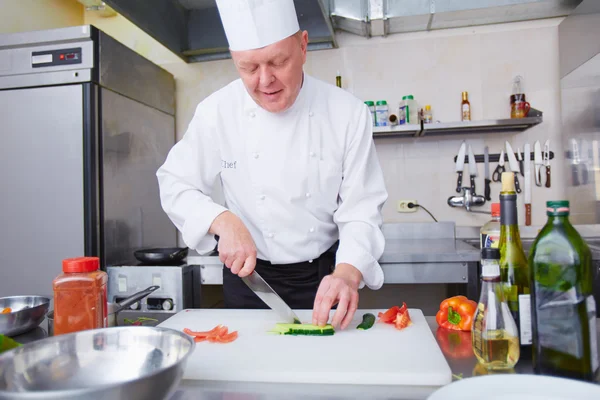 Chef experiente preparando legumes — Fotografia de Stock