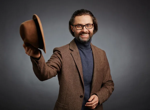 Hombre en elegante casual sosteniendo su sombrero — Foto de Stock