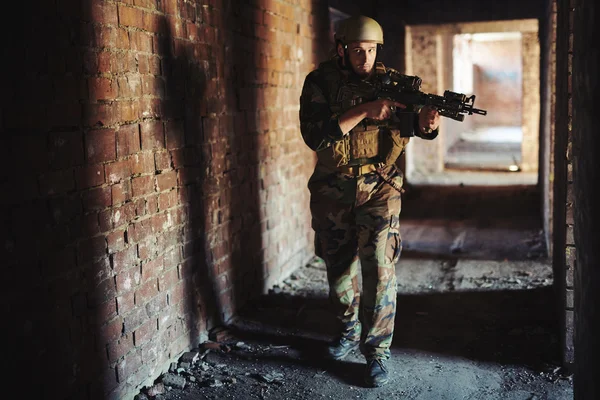 Soldado em camuflagem carregando arma — Fotografia de Stock