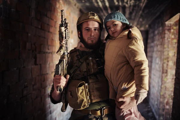 Guerreiro com arma segurando menina — Fotografia de Stock