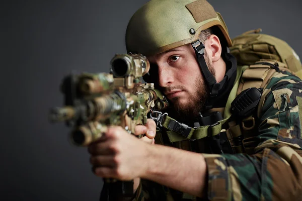 Soldier with ammunition shooting from rifle — Stock Photo, Image