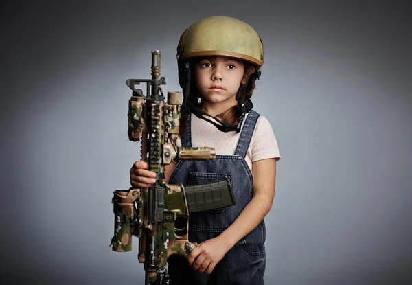 Chica con pistola usando casco protector — Foto de Stock