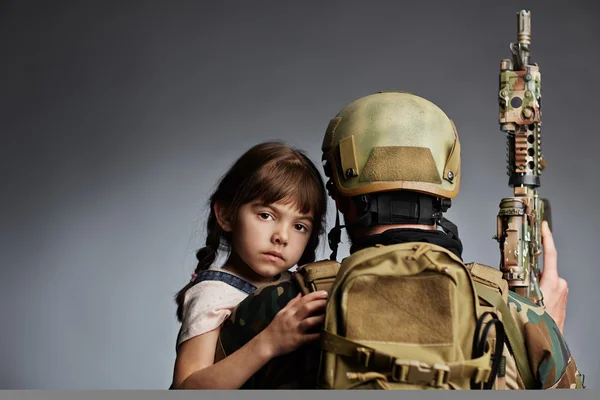 Warrior with gun holding  child — Stock Photo, Image