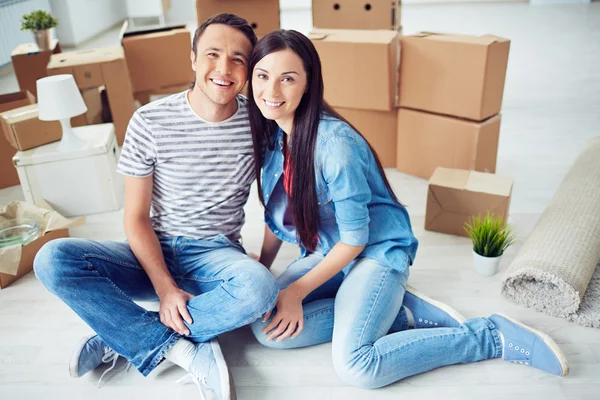 Couple sitting in empty new house — Stock Photo, Image