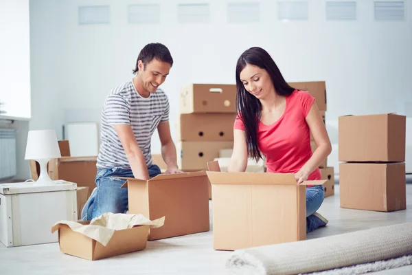 Pareja joven desempacando cajas — Foto de Stock