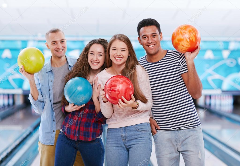 young friends with bowling balls