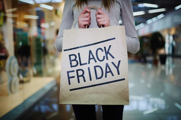 Cumpărător care arată sacul de hârtie Black Friday — Fotografie, imagine de stoc