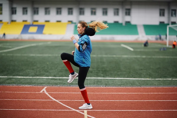 Donna che flette i muscoli nello stadio — Foto Stock