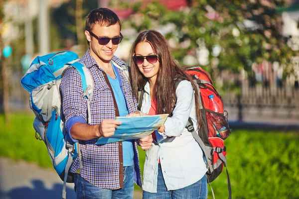 Casal de viajantes olhando para o mapa — Fotografia de Stock