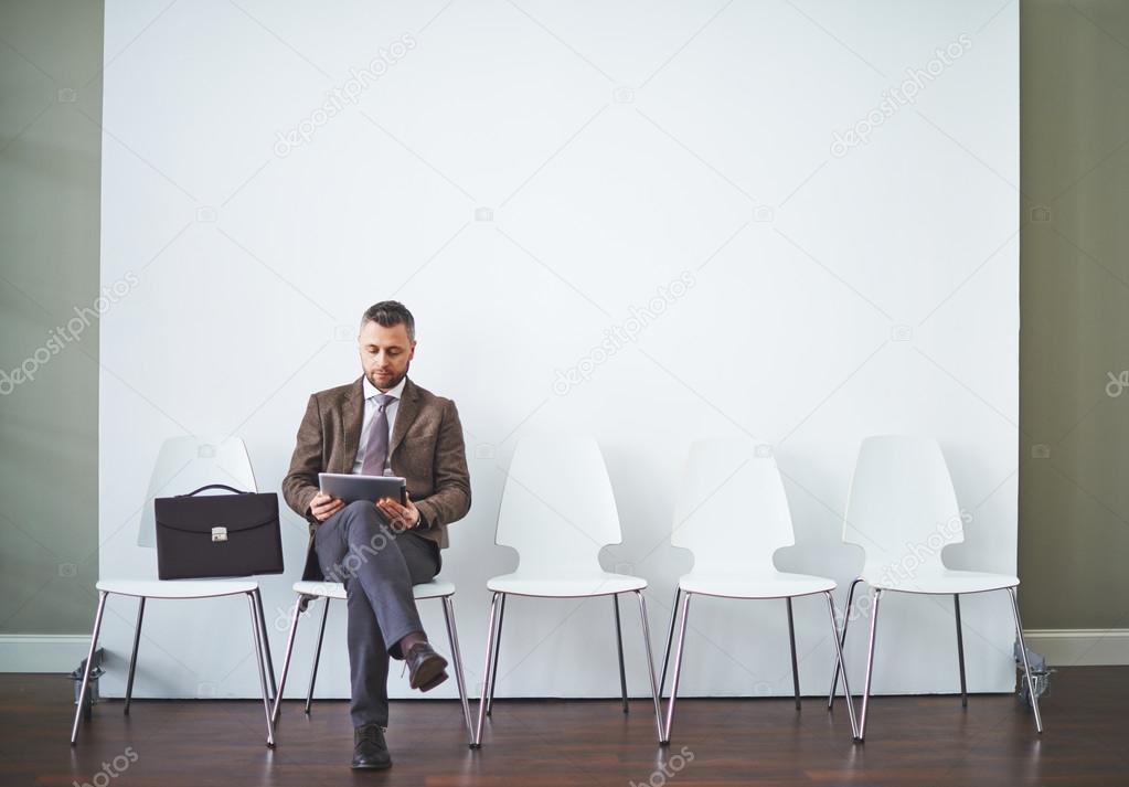 Businessman with touchpad waiting