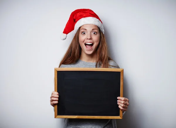 Girl in Santa hat holding blackboard — Stock Photo, Image