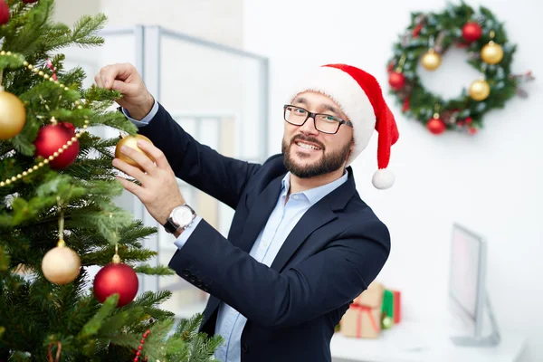 Geschäftsmann schmückt Weihnachtsbaum — Stockfoto