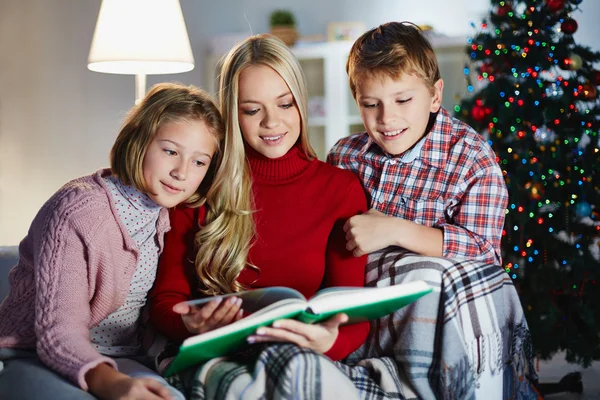 Femme lisant un livre à ses enfants — Photo