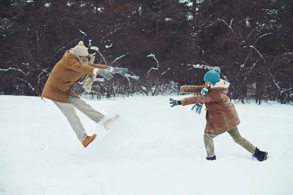 Mannen och hans son spelar i snödriva — Stockfoto