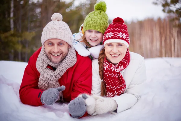 Lycklig familj liggande i snödriva — Stockfoto