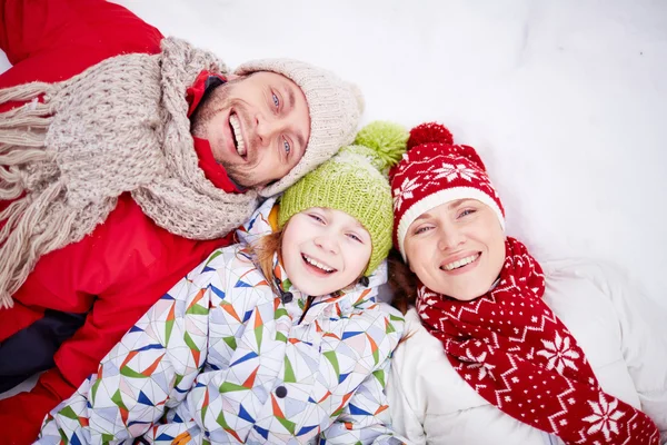 Parents et fille couchés sur la neige — Photo