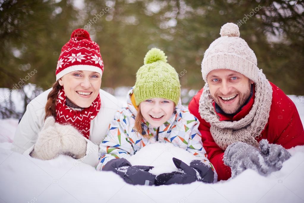 Joyful family lying in snowdrift