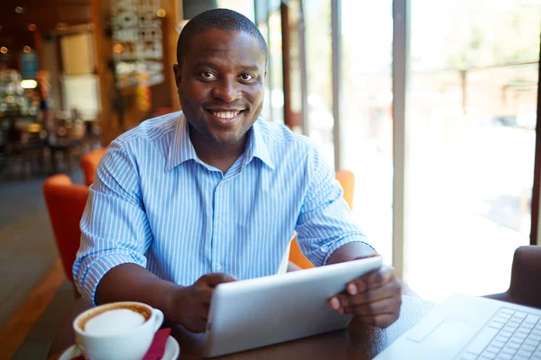 Homme souriant utilisant une tablette numérique — Photo