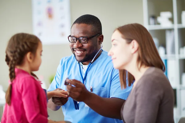 Pediatrician looking at little girl — Stock Photo, Image