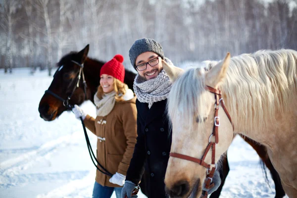 Jeune couple heureux avec des chevaux — Photo