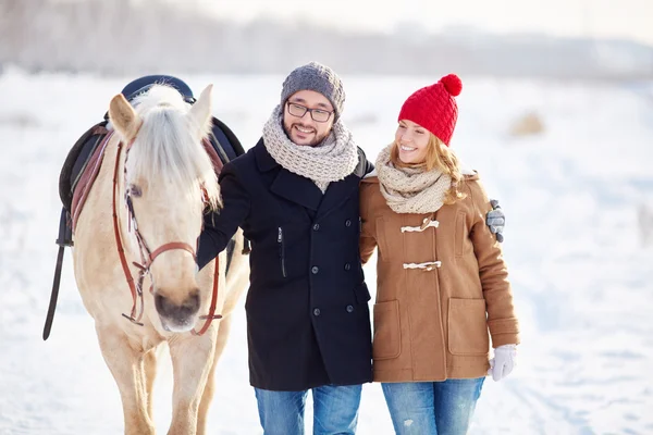 Joven pareja feliz con caballos —  Fotos de Stock