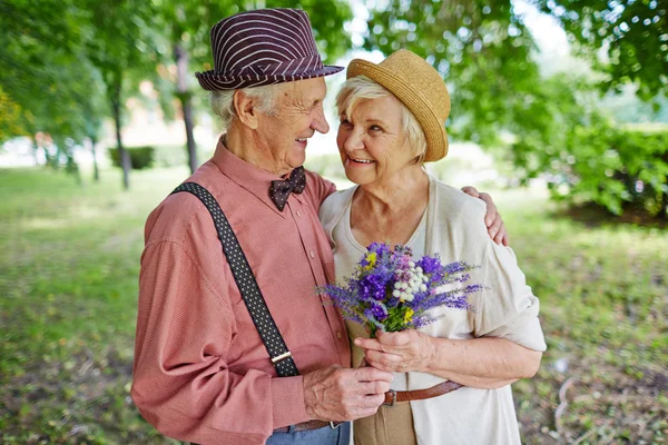 Mature lovely couple with flowers — Stock Photo, Image