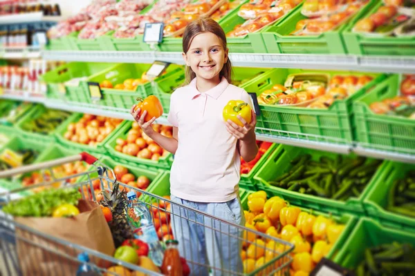 Dívka, volba papriky v supermarketu — Stock fotografie