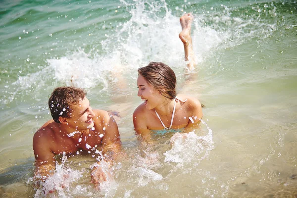 Pareja salpicando en el agua —  Fotos de Stock