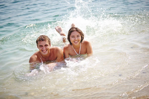 Couple splashing in water — Stock Photo, Image