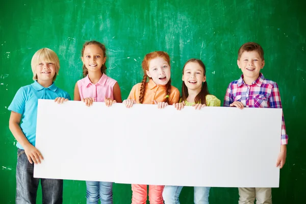 Group of schoolchildren with billboard — Stock Photo, Image