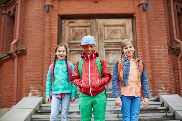 Happy schoolkids  leaving school — Stock Photo, Image