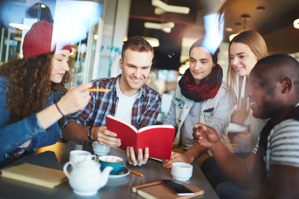 Amigos adolescentes leyendo en la cafetería —  Fotos de Stock