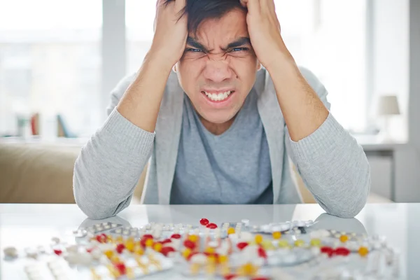 Angry man with pills — Stock Photo, Image