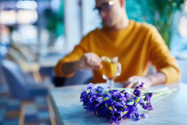 Flores en la mesa con el hombre —  Fotos de Stock