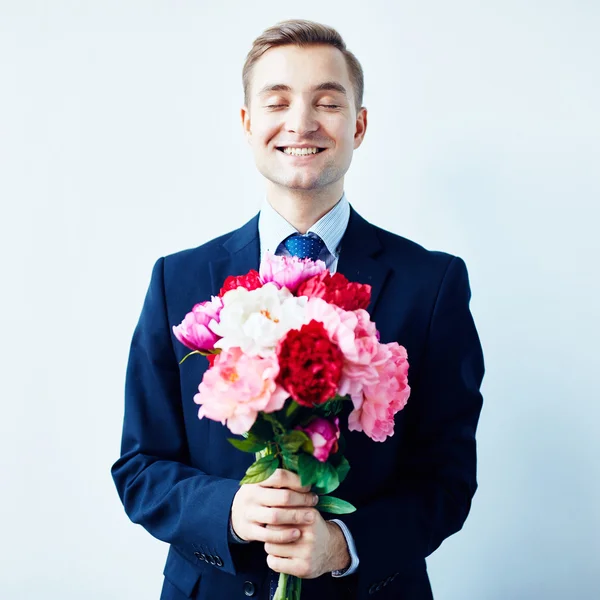 Hombre joven con flores de peonía — Foto de Stock