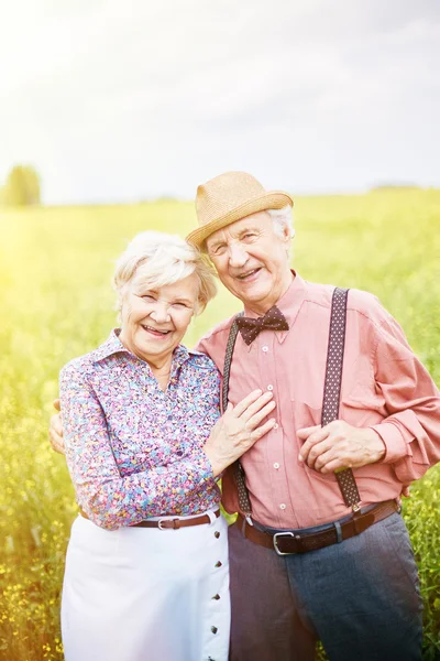 Glada pensionärer på äng — Stockfoto